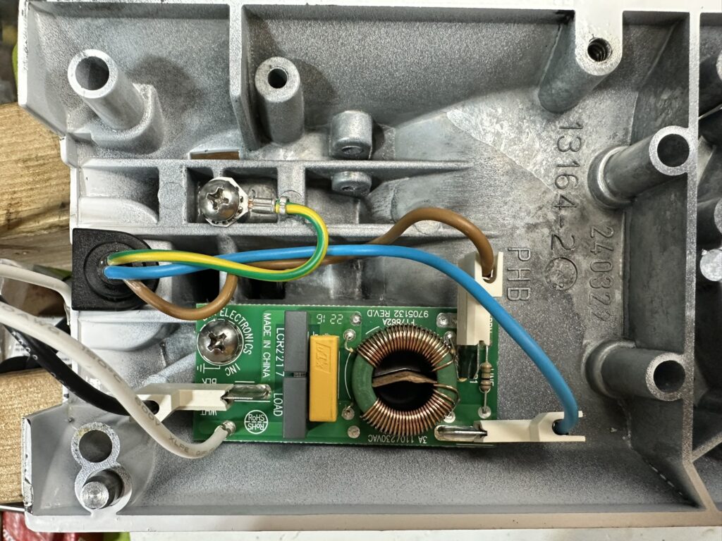 Photo of the inside of a K45-type lower gear housing, with the  line filter board and cord ground lead in place and secured.