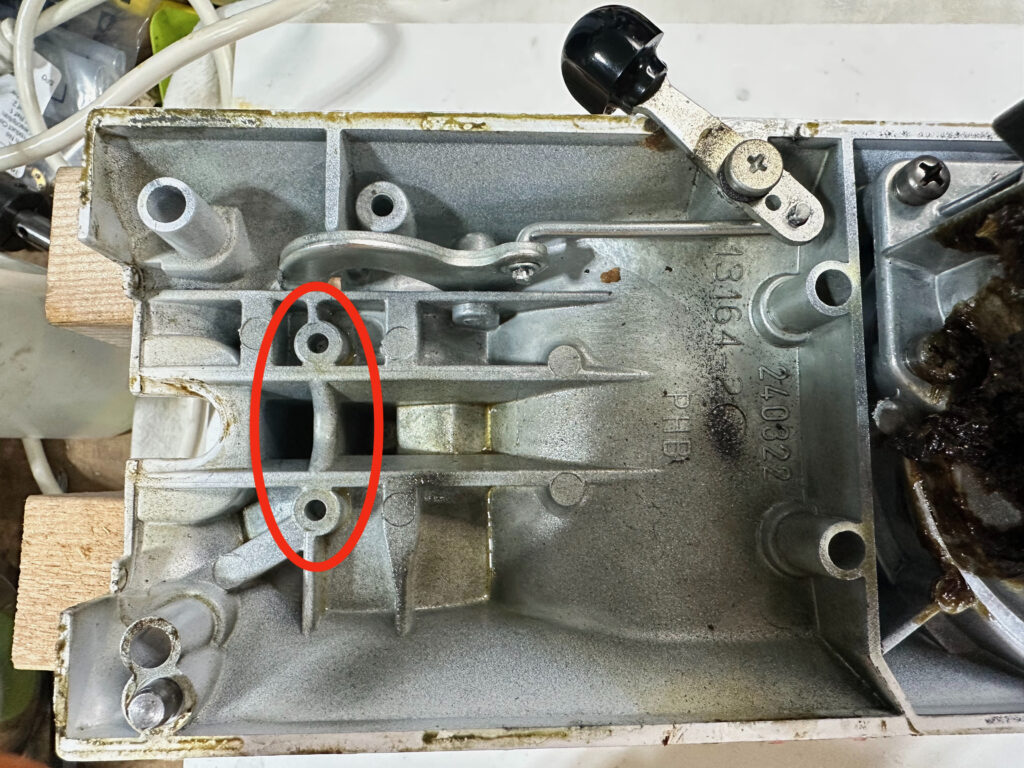 Photo of the inside of a K45-type lower gear housing, with the mounting and ground points for the line filter board circled with a red oval.